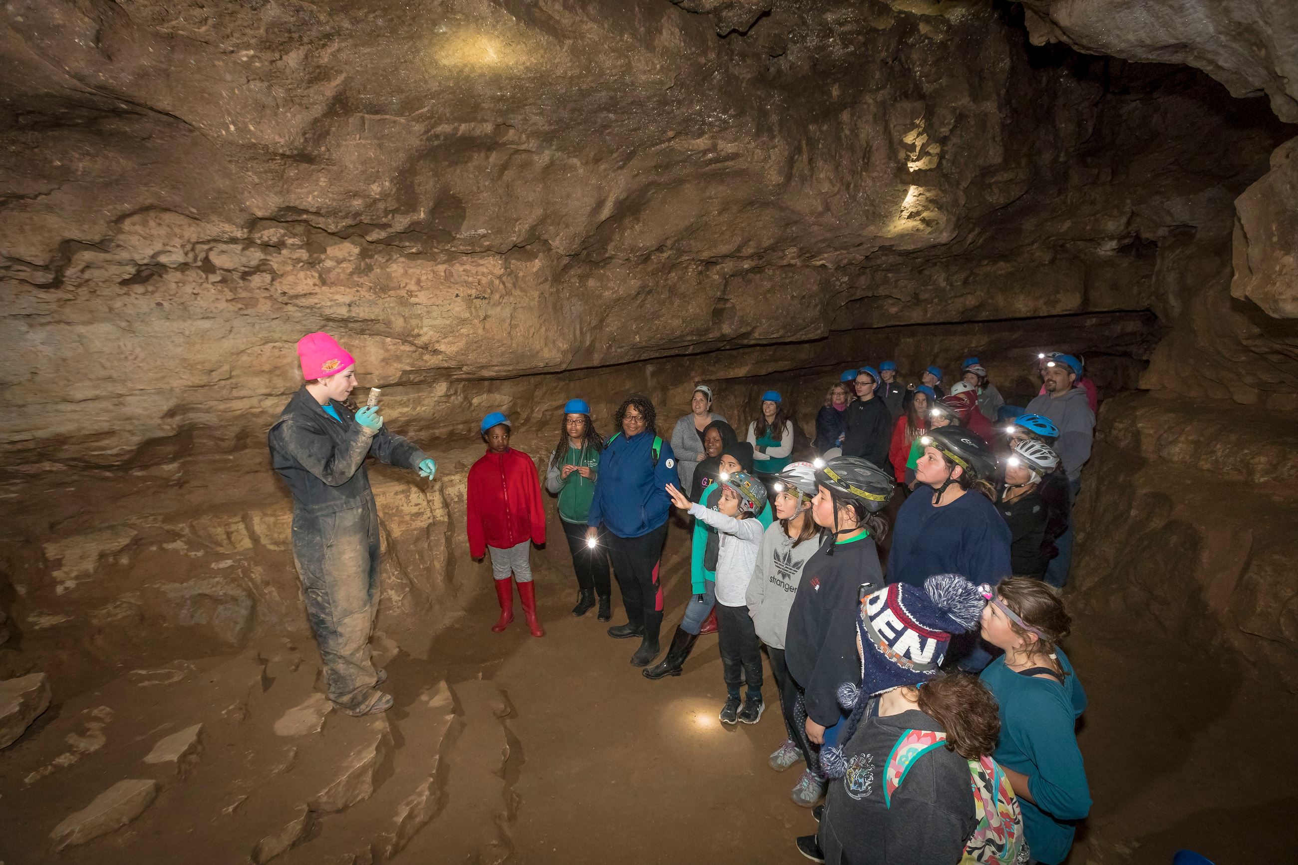 Instructor talking with a group inside a cave